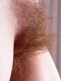Her long and thick pubic hair looks sexy in close up as the teen strips